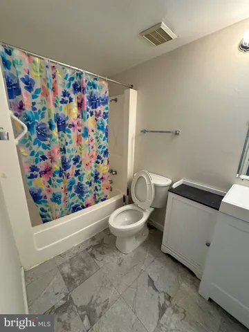 a bathroom with a toilet and a shower curtain