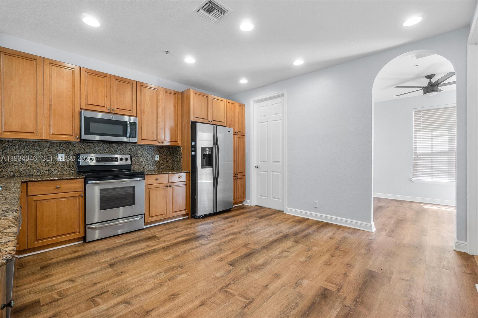 888 University Boulevard Jupiter, FL 33458 - Photo 13 of 41 a kitchen with granite countertop a refrigerator and a stove top oven