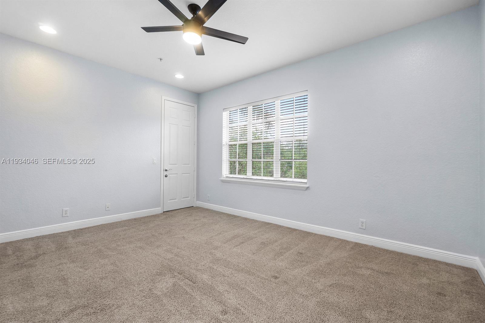 888 University Boulevard Jupiter, FL 33458 - Photo 23 of 41 an empty room with ceiling fan and windows