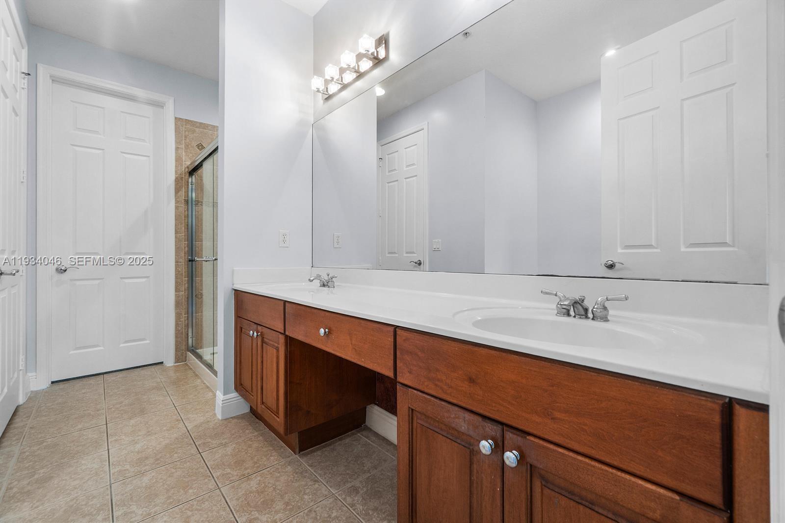 888 University Boulevard Jupiter, FL 33458 - Photo 29 of 41 a bathroom with a double vanity sink and a mirror