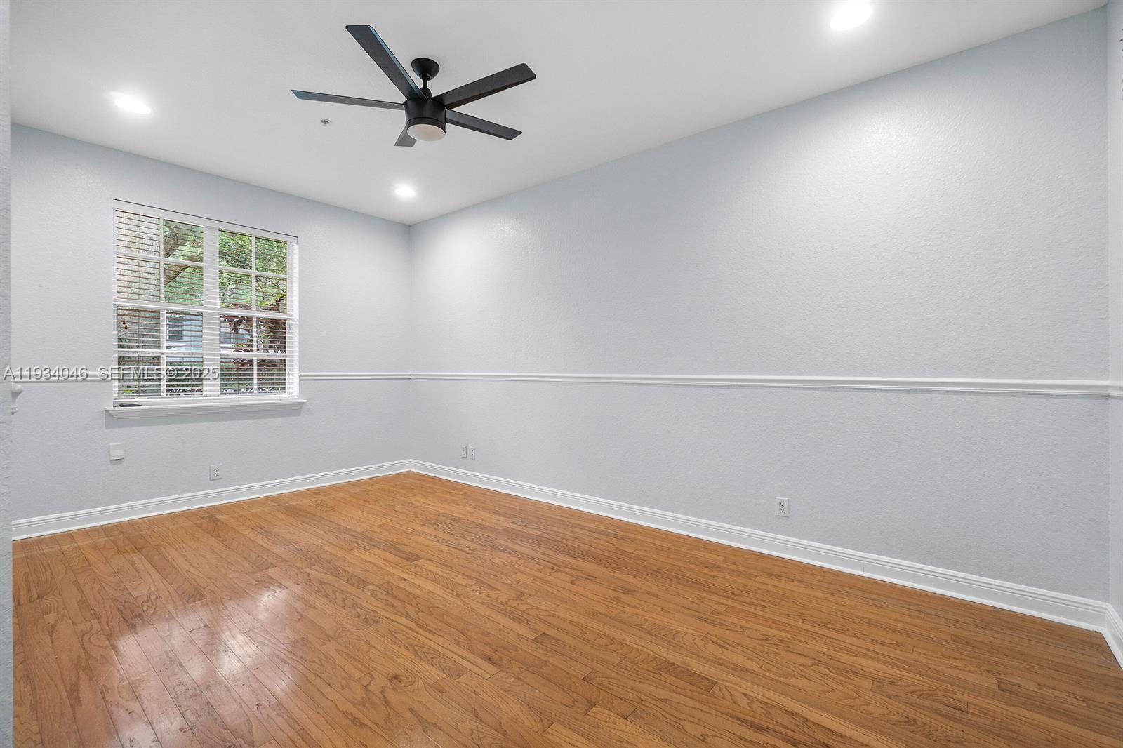 888 University Boulevard Jupiter, FL 33458 - Photo 5 of 41 an empty room with wooden floor and windows