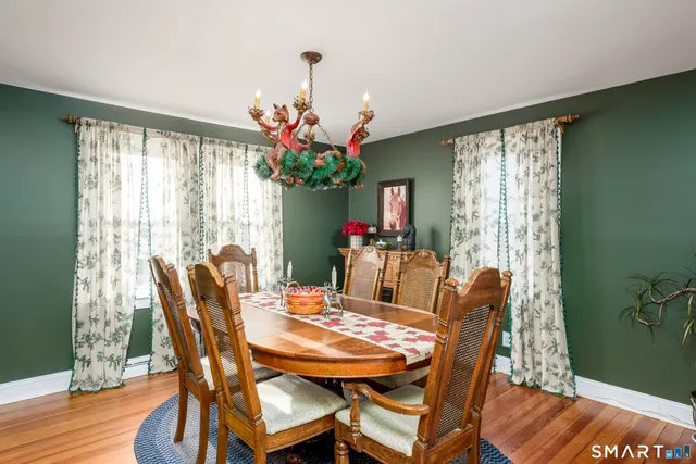 a dining room with furniture potted plants and wooden floor