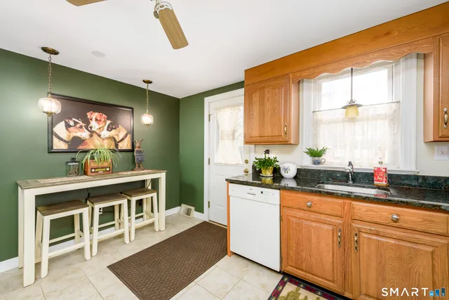 a kitchen with stainless steel appliances granite countertop a sink a stove cabinets and a window