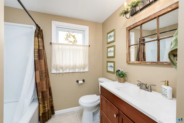 a bathroom with a sink a toilet and a window