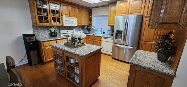 a kitchen with stainless steel appliances granite countertop a refrigerator a stove and a sink