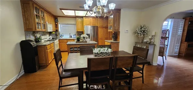 a dining room with furniture a chandelier and wooden floor