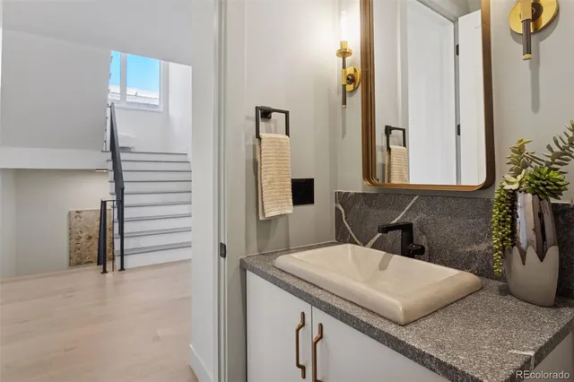a bathroom with a granite countertop sink and a mirror
