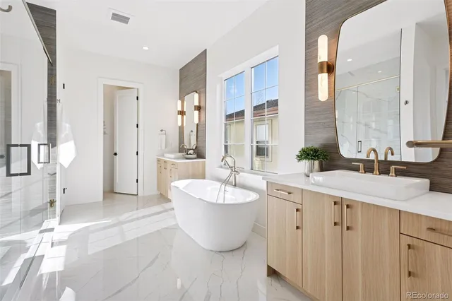 a spacious bathroom with a double vanity sink a mirror and a bathtub