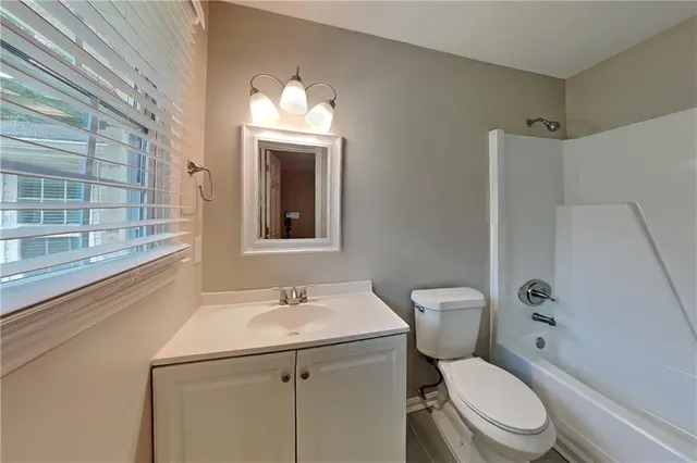 a bathroom with a toilet sink vanity and mirror