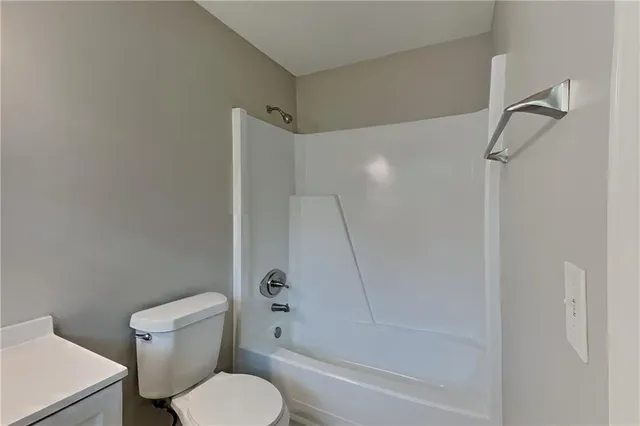 a white toilet and tub sitting next to a bathroom sink