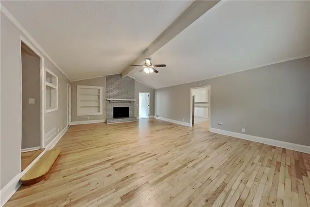 a view of a livingroom with wooden floor and a ceiling fan