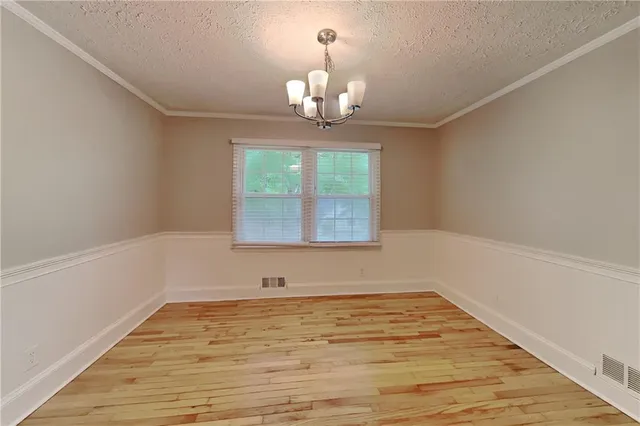 a view of wooden floor and a chandelier in a room