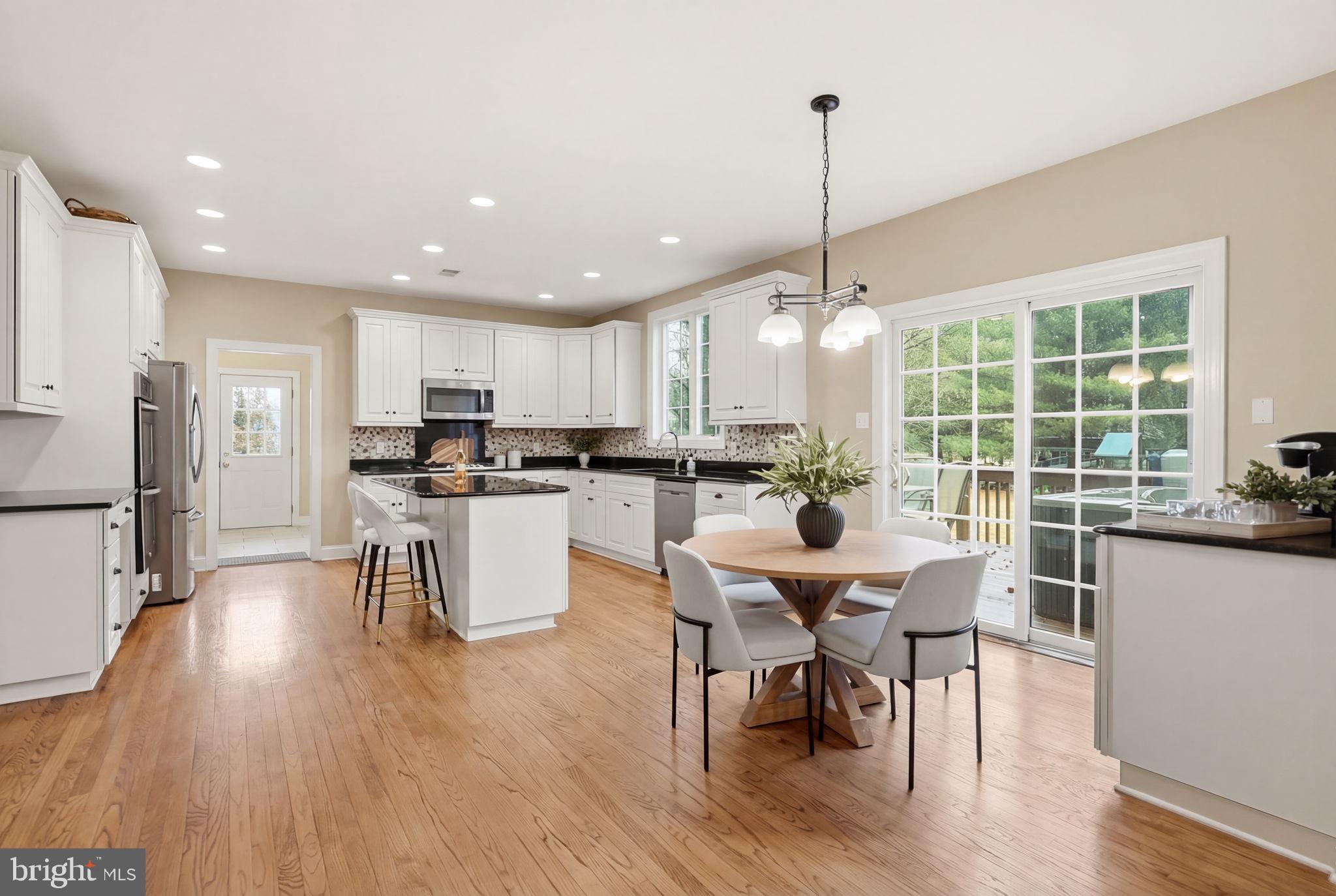 22 Springlea Lane Chester Springs, PA 19425 - Photo 14 of 80 a kitchen with stainless steel appliances kitchen island granite countertop a table chairs and a wooden cabinets