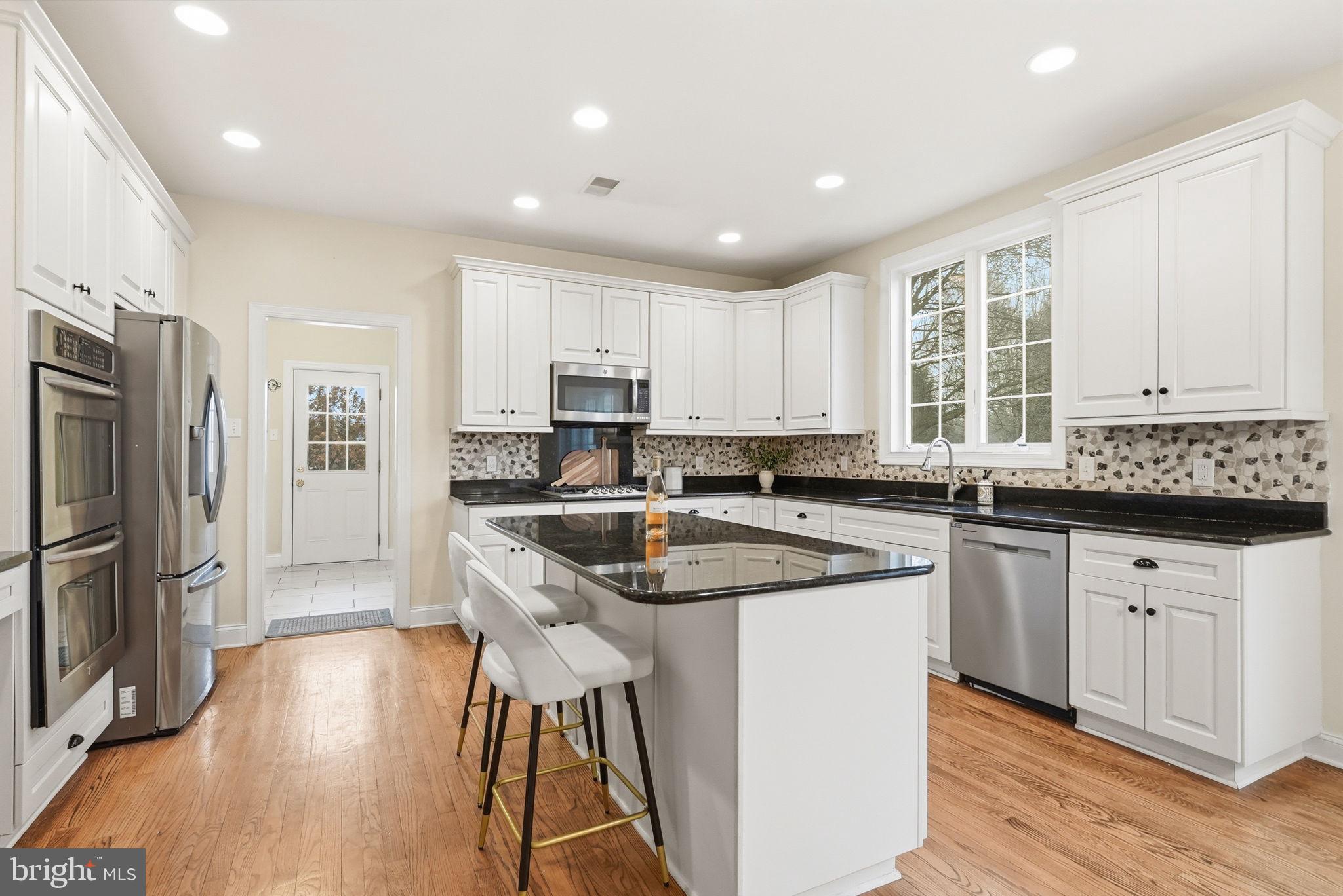 22 Springlea Lane Chester Springs, PA 19425 - Photo 17 of 80 a kitchen with stainless steel appliances granite countertop a refrigerator a sink dishwasher a stove and white cabinets with wooden floor
