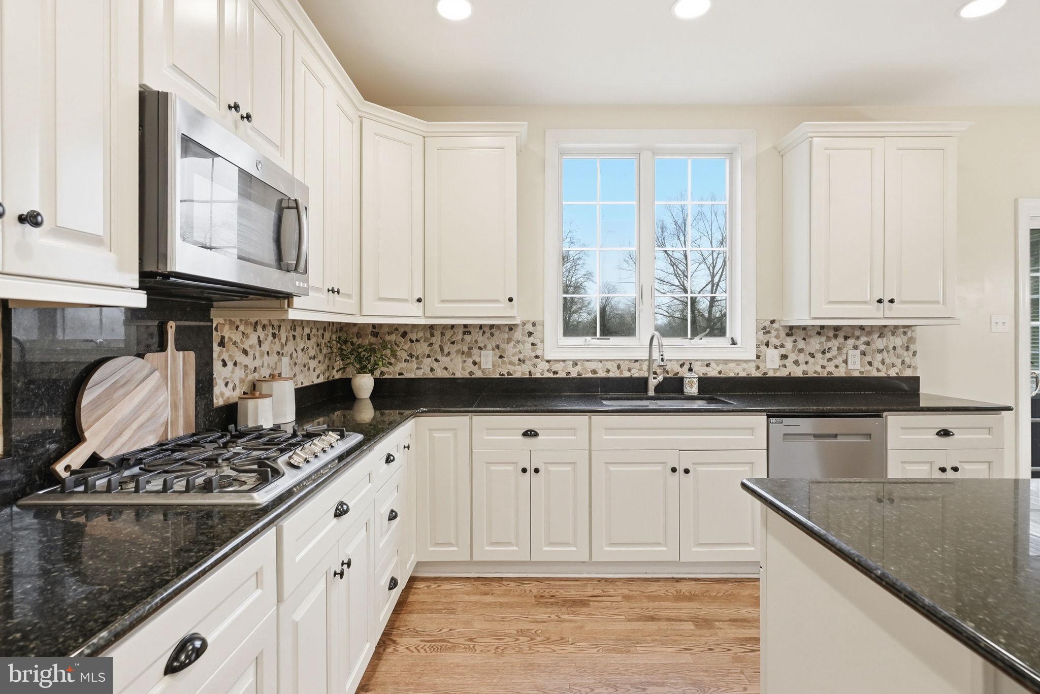 22 Springlea Lane Chester Springs, PA 19425 - Photo 21 of 80 a kitchen with granite countertop a sink stove and cabinets