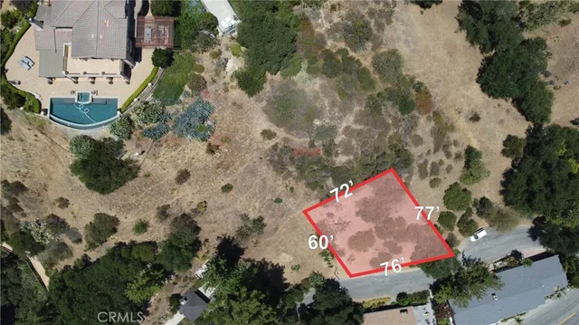 an aerial view of a house with a yard and parking space