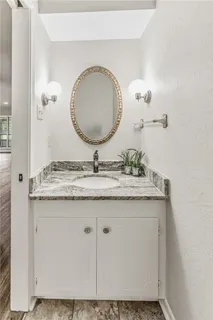 a bathroom with a granite countertop sink and a mirror