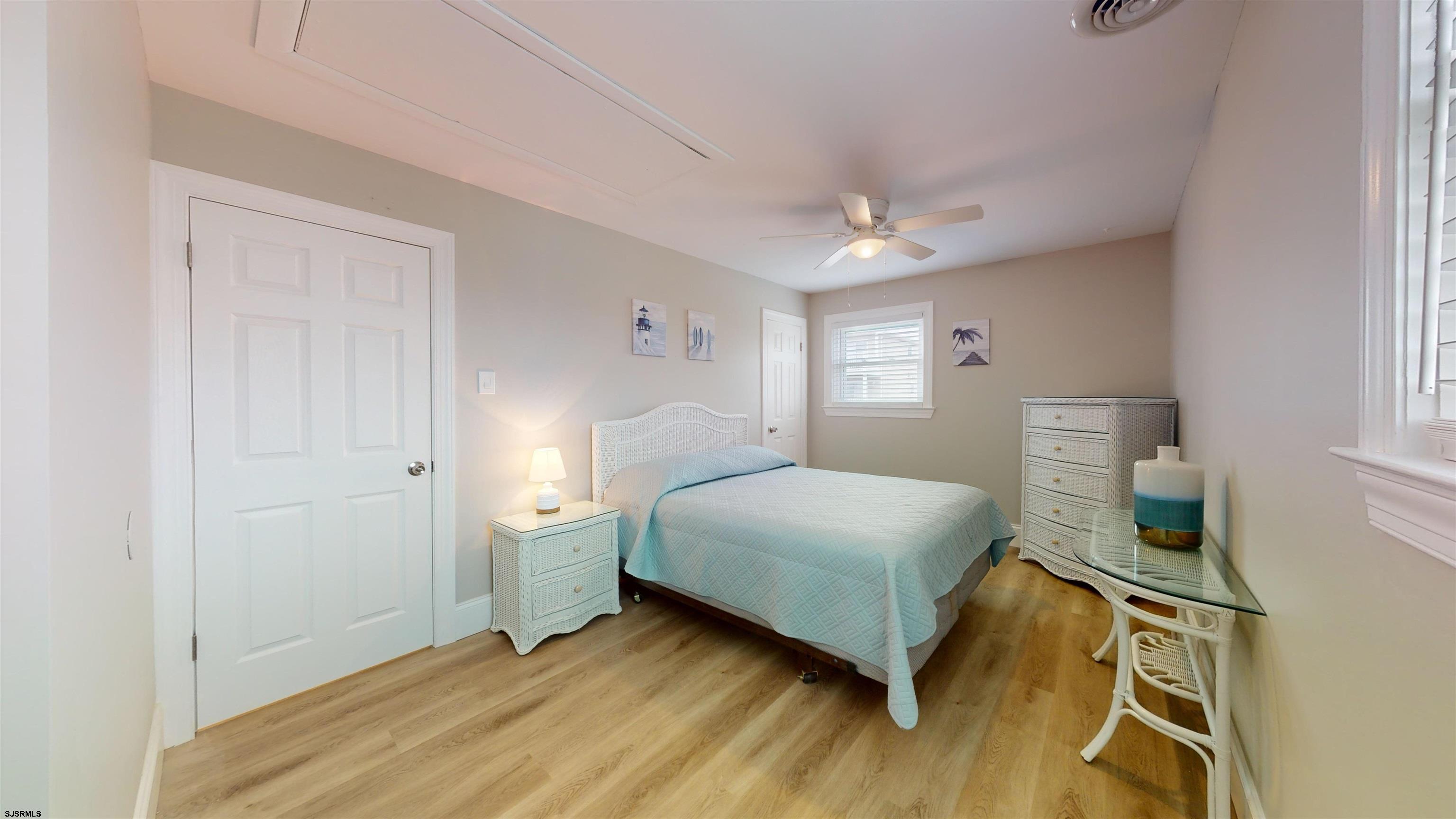 251 7th Street South, Unit 2 Brigantine, NJ 08203 - Photo 16 of 21 a bedroom with a bed and a chandelier