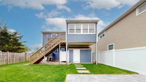 a view of a house with a yard and stairs