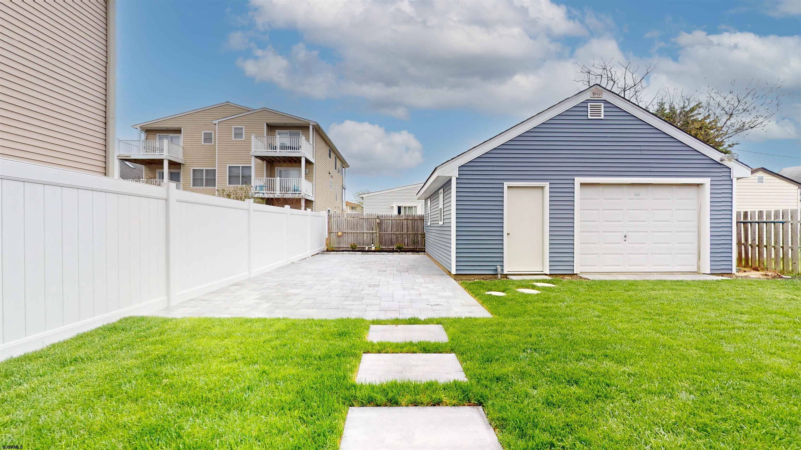 251 7th Street South, Unit 2 Brigantine, NJ 08203 - Photo 3 of 21 a front view of a house with a yard and garage