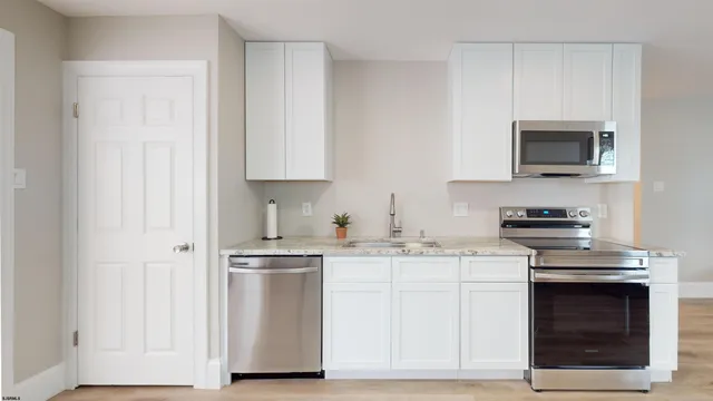 a kitchen with white cabinets and stainless steel appliances
