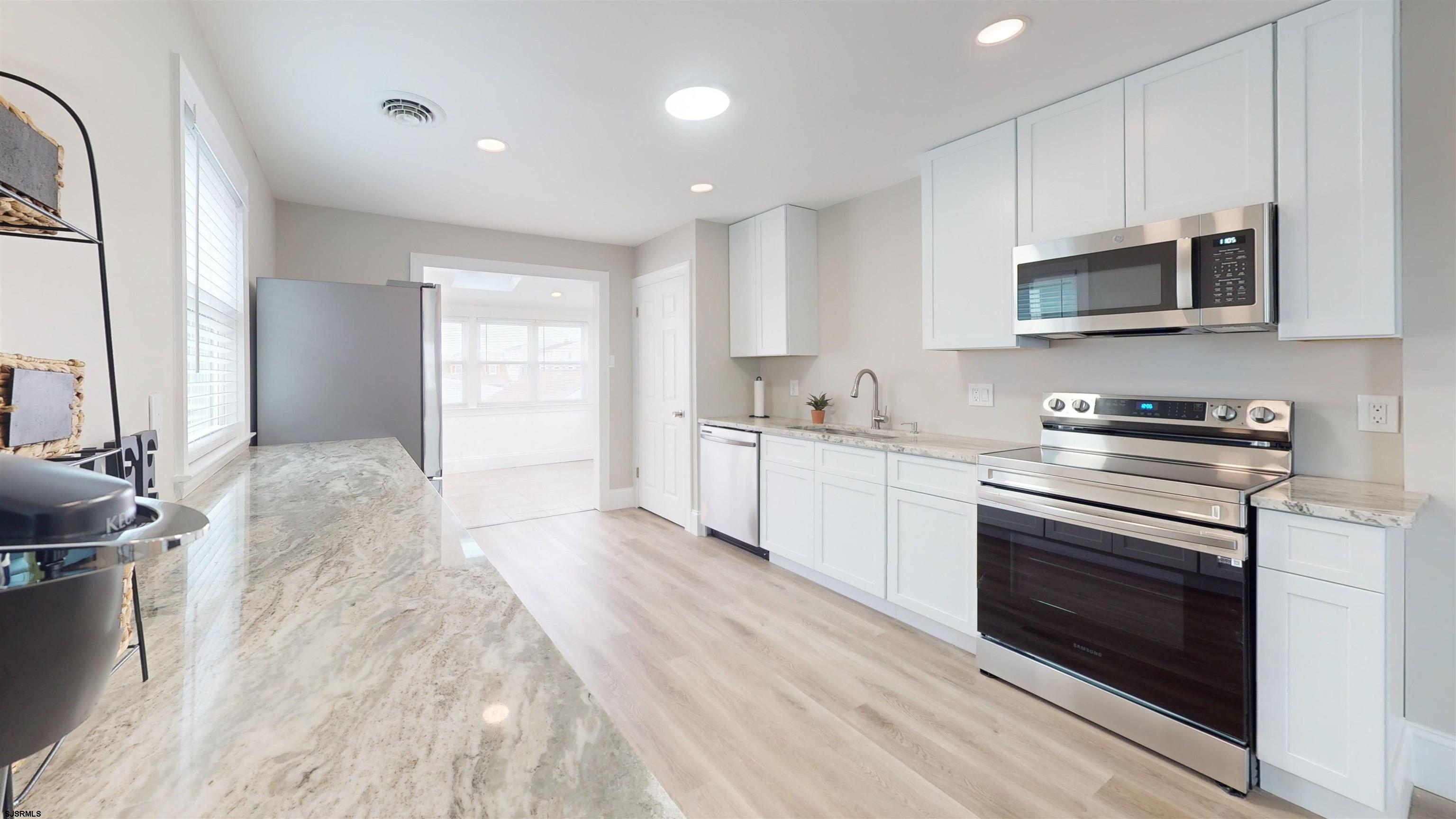 251 7th Street South, Unit 2 Brigantine, NJ 08203 - Photo 10 of 21 a kitchen with stainless steel appliances granite countertop a stove and a sink
