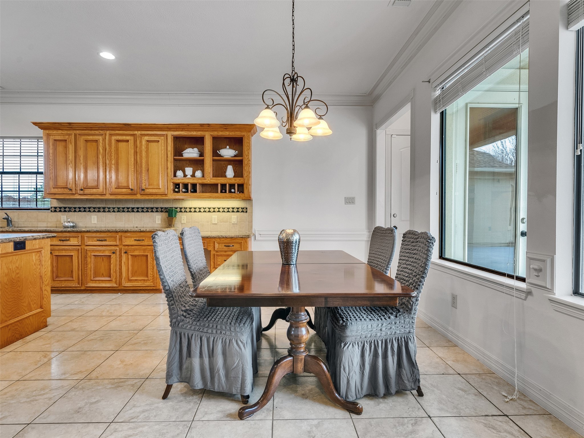6914 Sandwedge Point Court Spring, TX 77389 - Photo 20 of 50 This bright dining area features a wooden table with elegant chairs, large windows for natural light, and an adjacent kitchen with ample cabinetry and granite countertops, perfect for hosting and family meals.