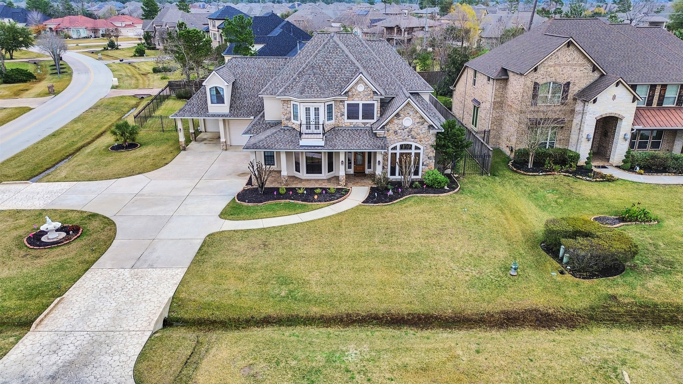 6914 Sandwedge Point Court Spring, TX 77389 - Photo 2 of 50 This is a spacious two-story home with a charming brick exterior and a large, well-maintained front yard. It features a multi-car driveway, a covered front porch, and elegant landscaping, set in a quiet, suburban neighborhood.