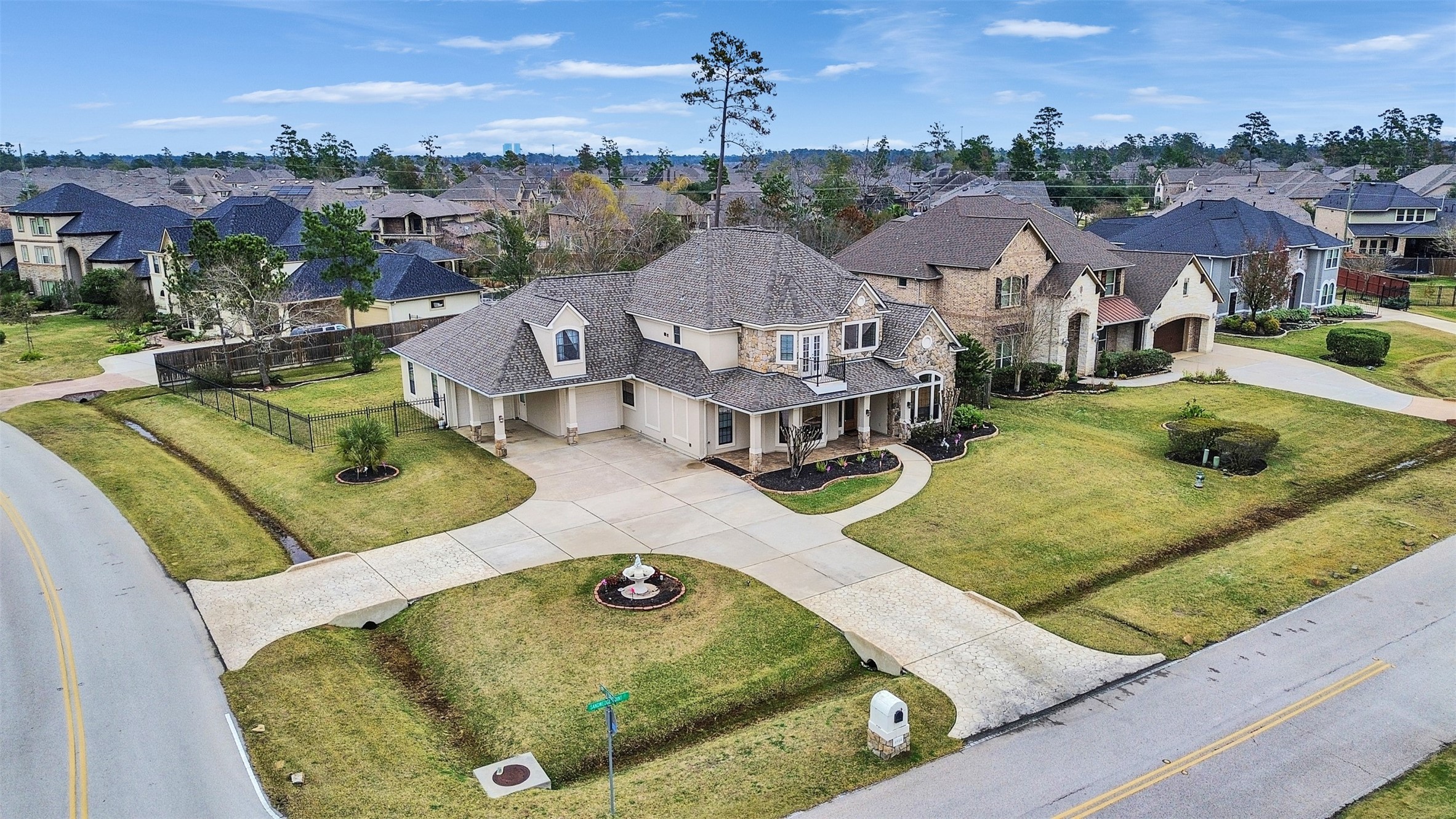 6914 Sandwedge Point Court Spring, TX 77389 - Photo 3 of 50 This photo showcases a spacious two-story home on a corner lot in a well-maintained suburban neighborhood. The property features a large driveway, manicured lawns, and a mix of brick and siding exterior. The surrounding area is filled with similar upscale homes, offering a sense of community and tranquility.