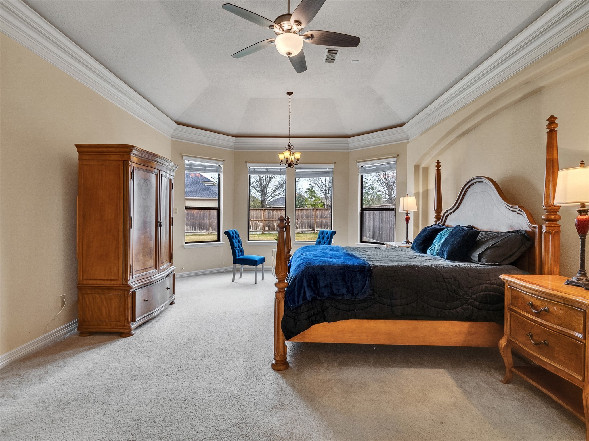 6914 Sandwedge Point Court Spring, TX 77389 - Photo 33 of 50 This spacious bedroom features a vaulted ceiling with a fan, ample natural light from multiple windows, and elegant crown molding. It includes classic wooden furniture, a large bed, and cozy carpeting, creating an inviting and comfortable space.