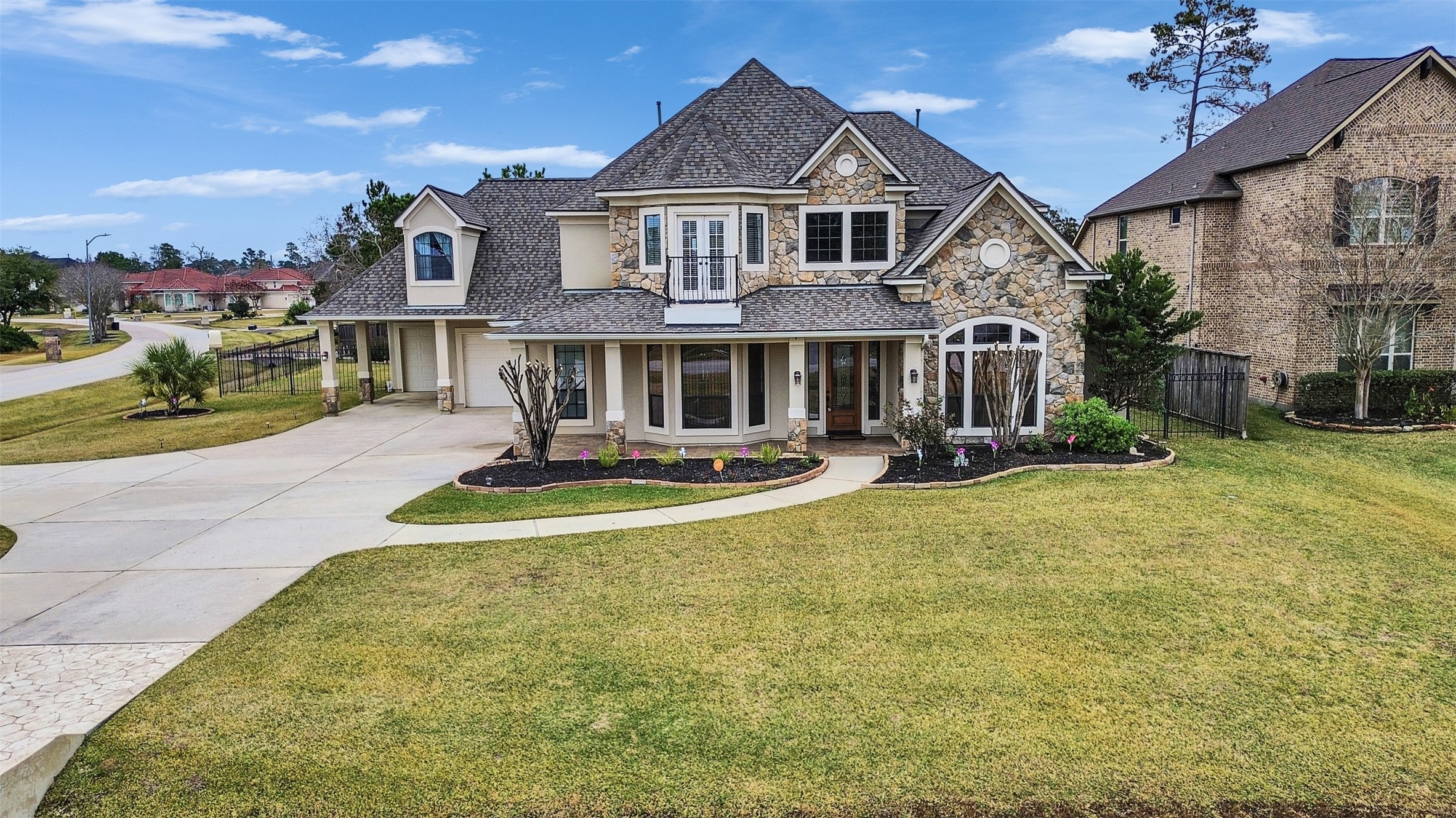 6914 Sandwedge Point Court Spring, TX 77389 - Photo 4 of 50 This beautiful two-story home features a charming stone facade, large windows, and a welcoming front porch. It's set on a spacious, well-maintained lawn with a curved driveway leading to a side garage. Located in a quiet neighborhood, it offers a blend of elegance and comfort.