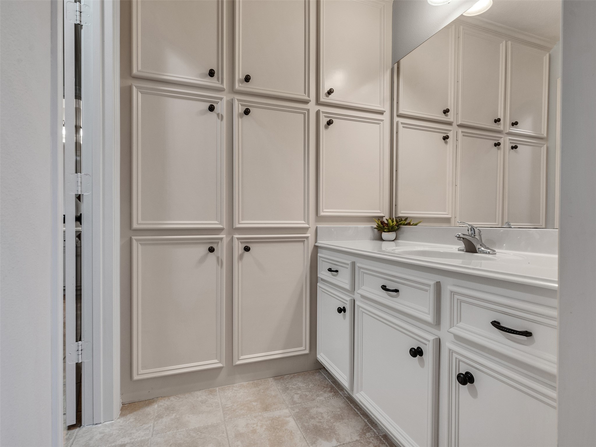 6914 Sandwedge Point Court Spring, TX 77389 - Photo 41 of 50 Bathroom with ample cabinetry, featuring white cabinets with dark handles, a sleek countertop, and a modern sink. The room is bright and has a clean, minimalist design.