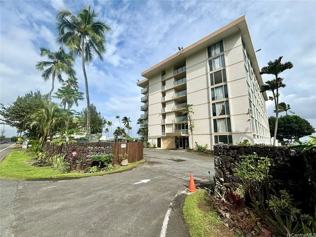 a front view of a building with a garden
