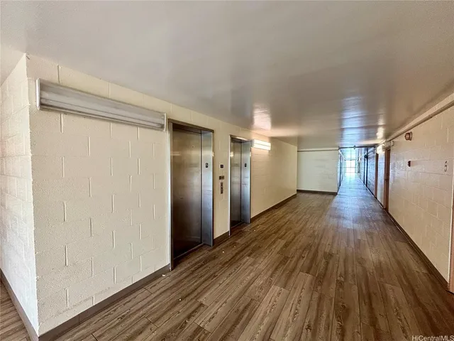 a view of a hallway with wooden floor