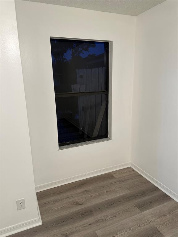 2825 Stoneway Lane Fort Pierce, FL 34982 - Photo 6 of 8 an empty room with wooden floor and windows