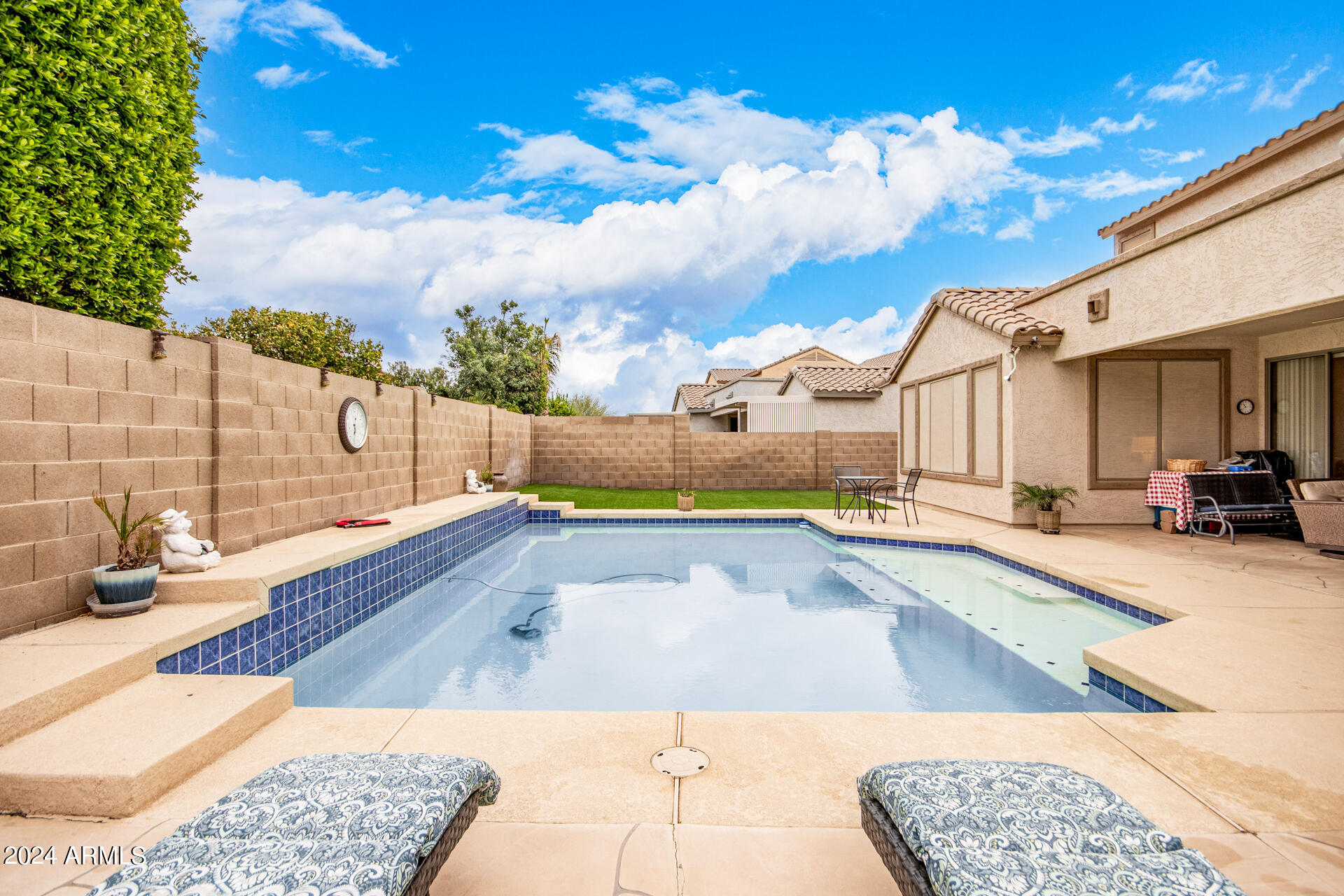 15224 West Redfield Road Surprise, AZ 85379 - Photo 24 of 28 a view of a swimming pool with a lounge chair and a chandelier