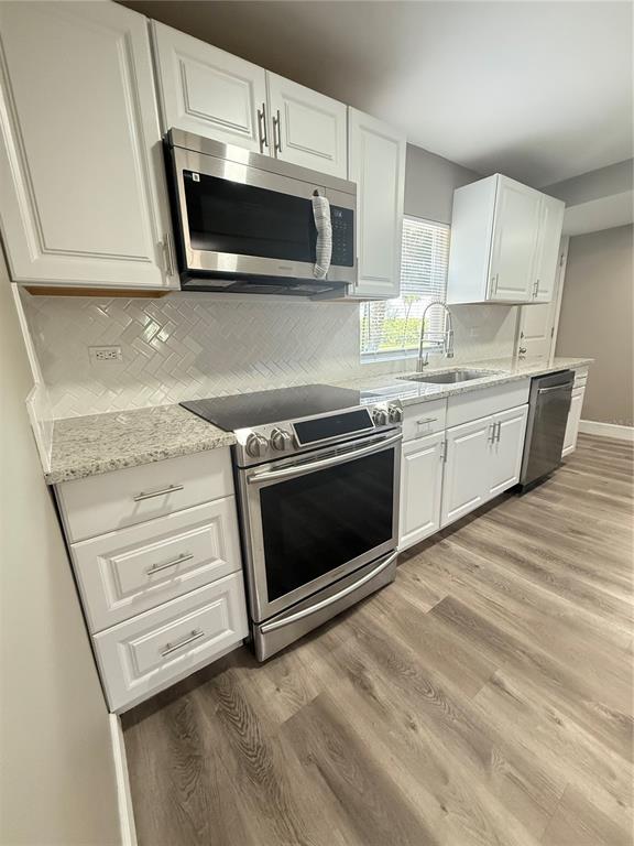 426 Becton Street Frostproof, FL 33843 - Photo 11 of 49 a kitchen with stainless steel appliances white cabinets and a stove top oven