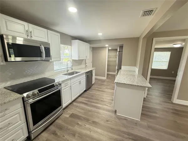 a kitchen with a sink and steel appliances