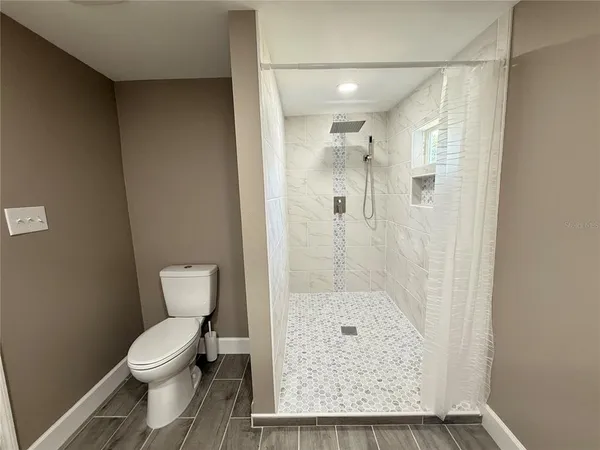 a bathroom with a granite countertop shower a toilet and a sink