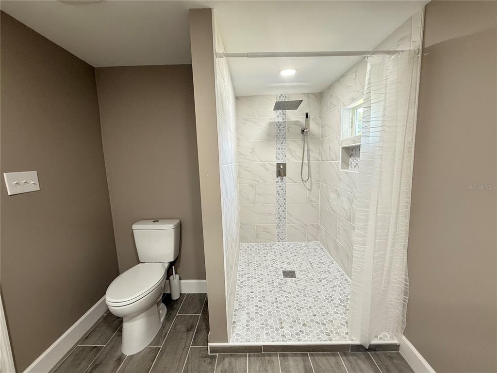 426 Becton Street Frostproof, FL 33843 - Photo 18 of 49 a bathroom with a granite countertop shower a toilet and a sink