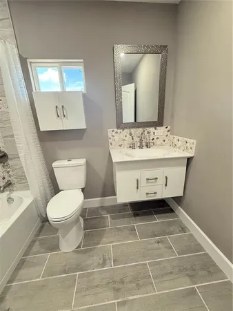 a bathroom with a sink toilet and mirror