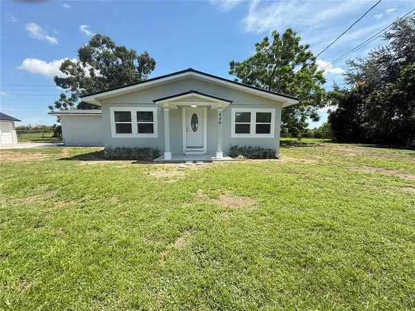 a front view of a house with yard and green space