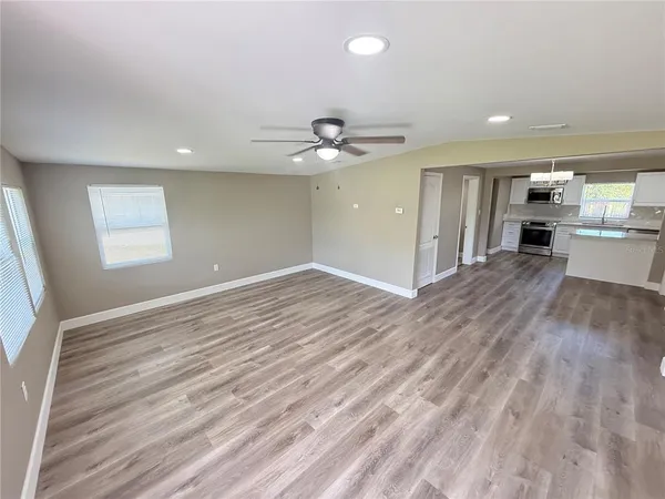 a view of a kitchen with wooden floor and a ceiling fan