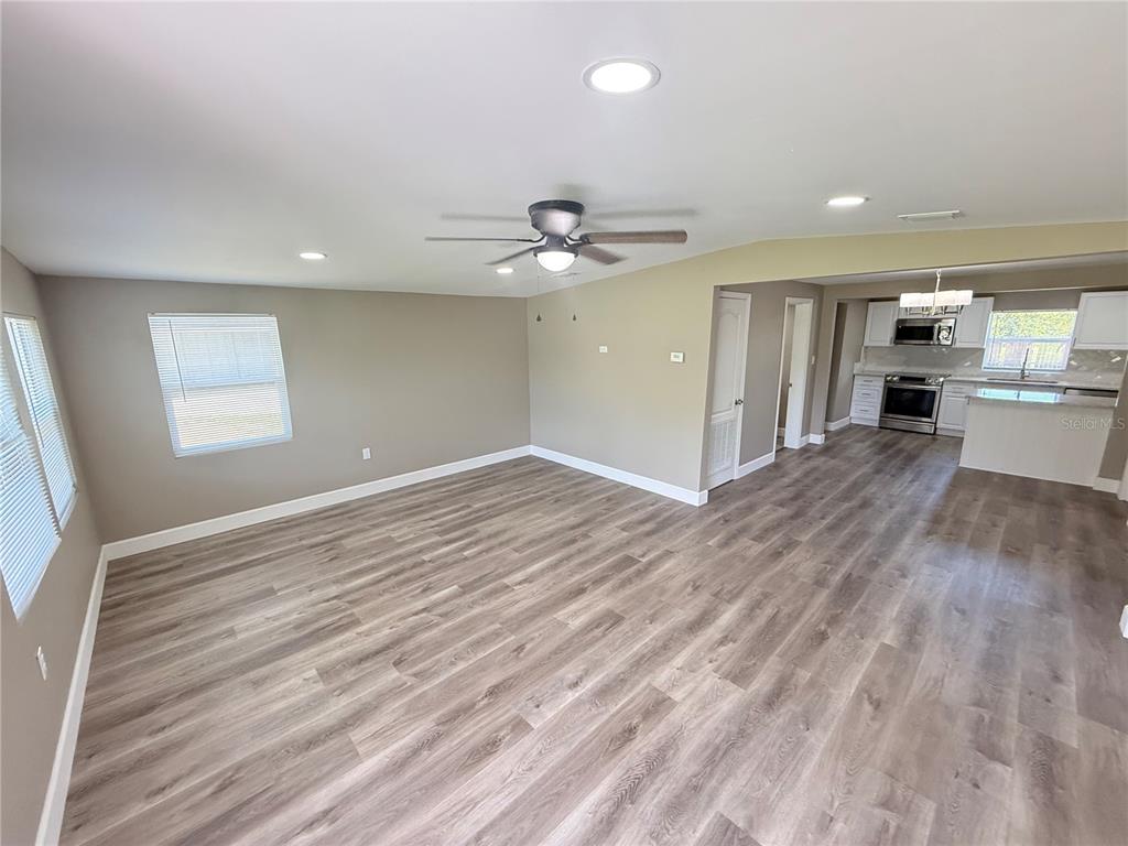426 Becton Street Frostproof, FL 33843 - Photo 9 of 49 a view of a kitchen with wooden floor and a ceiling fan