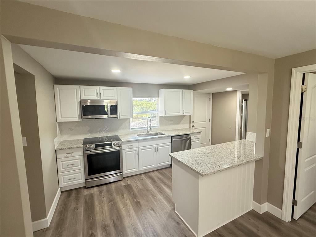 426 Becton Street Frostproof, FL 33843 - Photo 10 of 49 a kitchen with stainless steel appliances granite countertop a stove a sink and a refrigerator