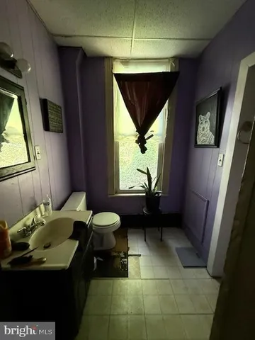 a living room with furniture a flat screen tv and gym equipment