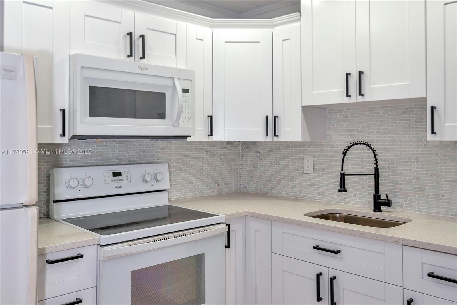 712 Division Avenue West Palm Beach, FL 33401 - Photo 2 of 37 a kitchen with white cabinets and sink