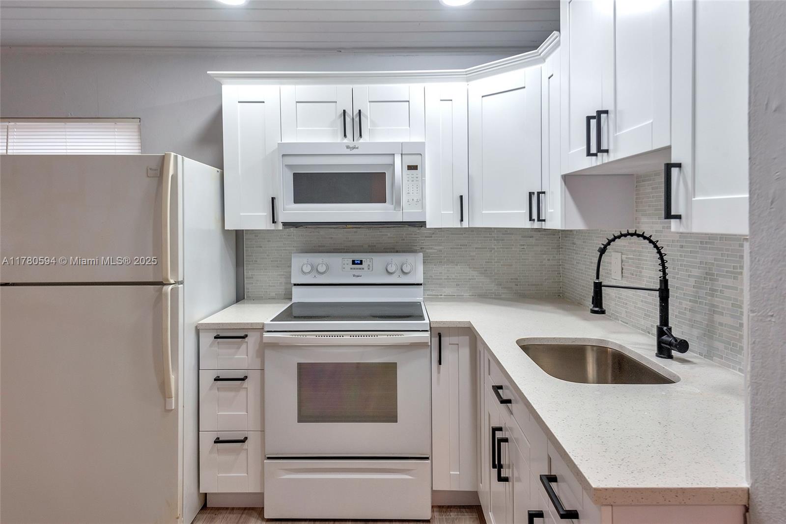 712 Division Avenue West Palm Beach, FL 33401 - Photo 24 of 37 a kitchen with a stove sink and refrigerator