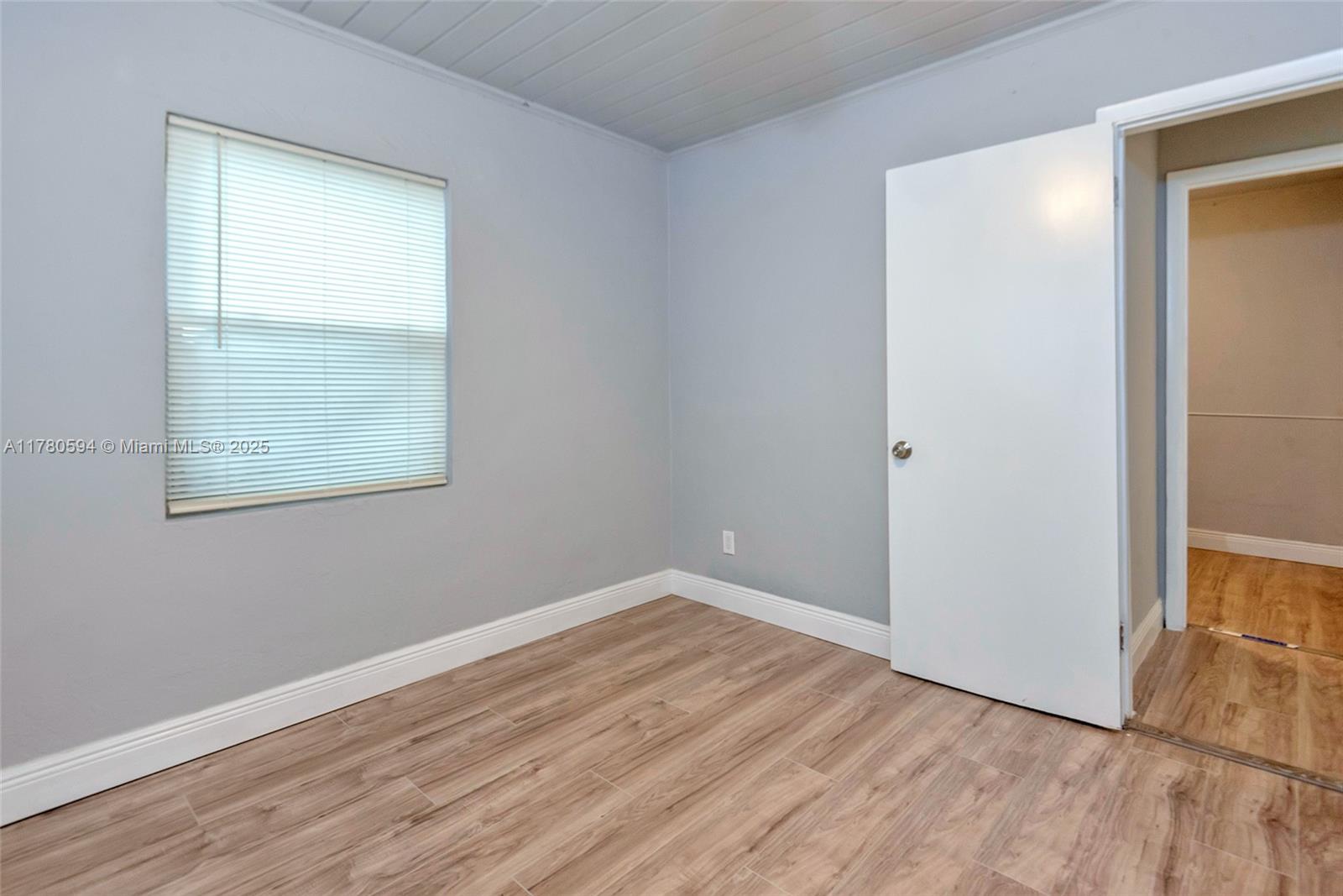 712 Division Avenue West Palm Beach, FL 33401 - Photo 5 of 37 an empty room with wooden floor and windows