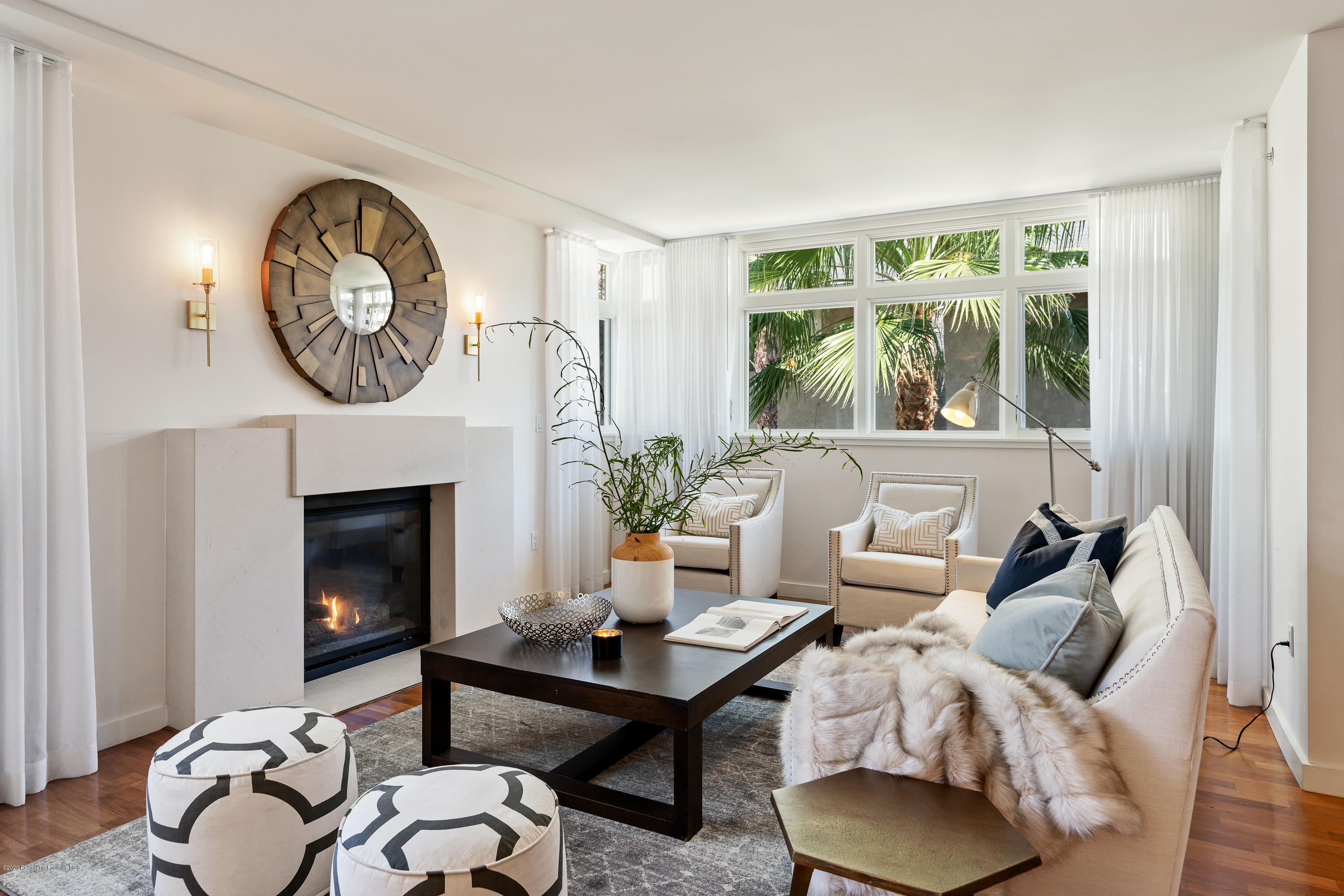 a living room with furniture a fireplace and a large window